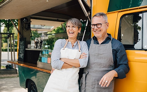 shop owners standing outside food truck